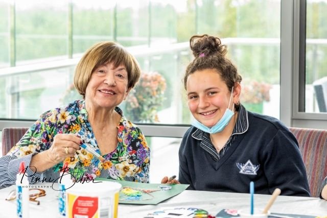 A young volunteer and a senior making crafts together